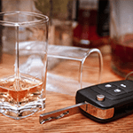 Car key on the bar with spilled alcohol and empty bottles